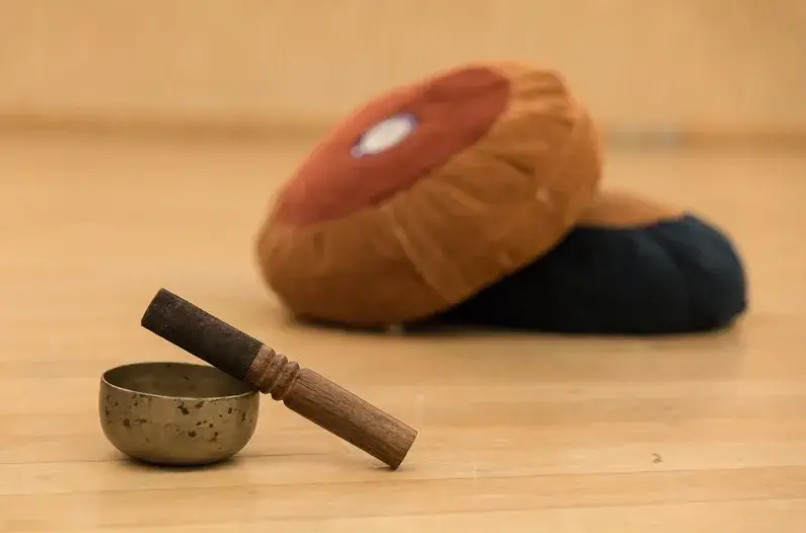 a singing bowl and cushions on the studio floor